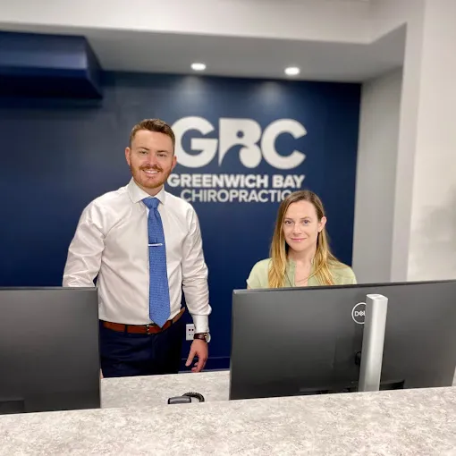Best Chiropractor Near Me Dr. Devon Barley of Greenwich Bay Chiropractic and Associate at Front Desk.